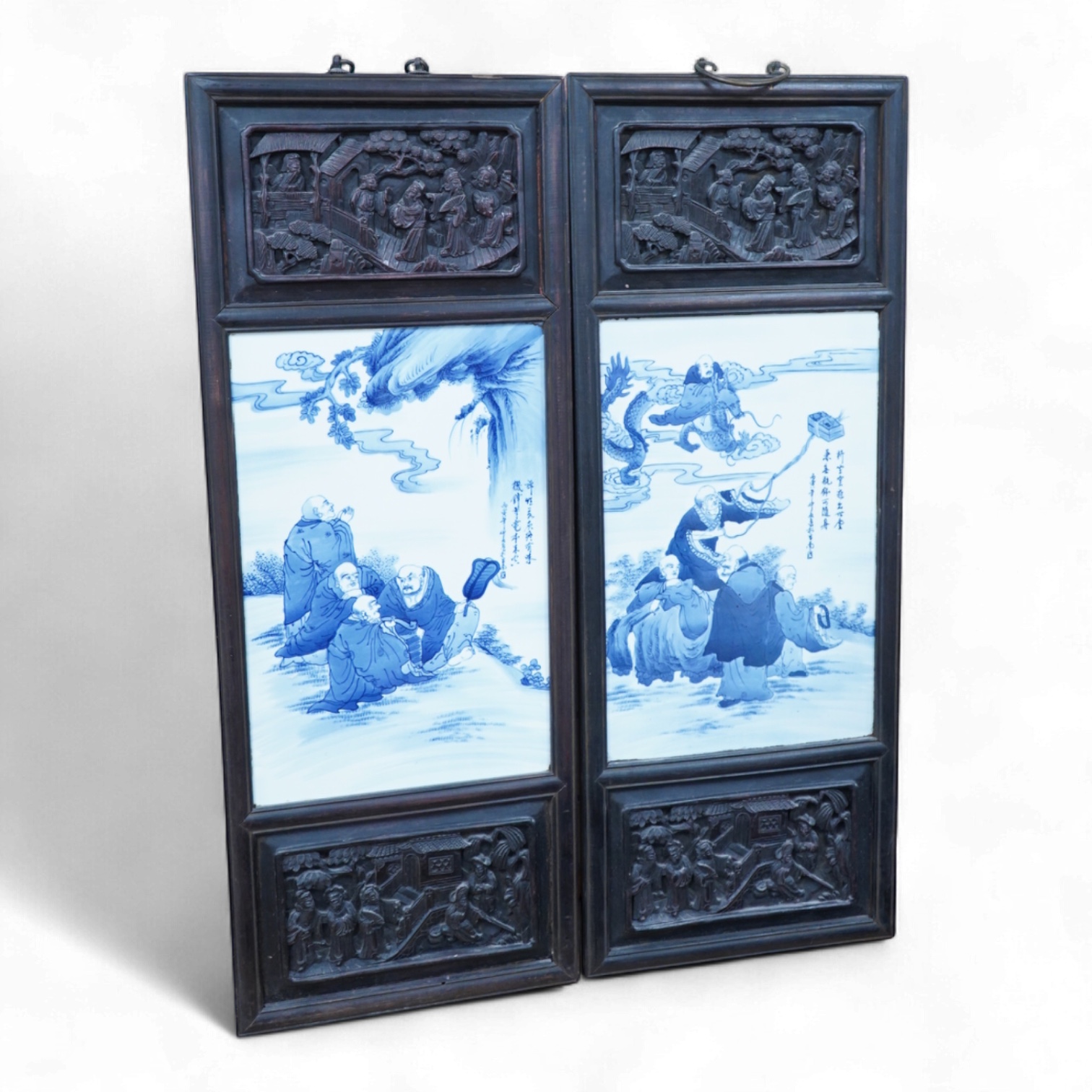 A pair of Chinese blue and white porcelain plaques, inset carved wood frames, 84cm x 32cm